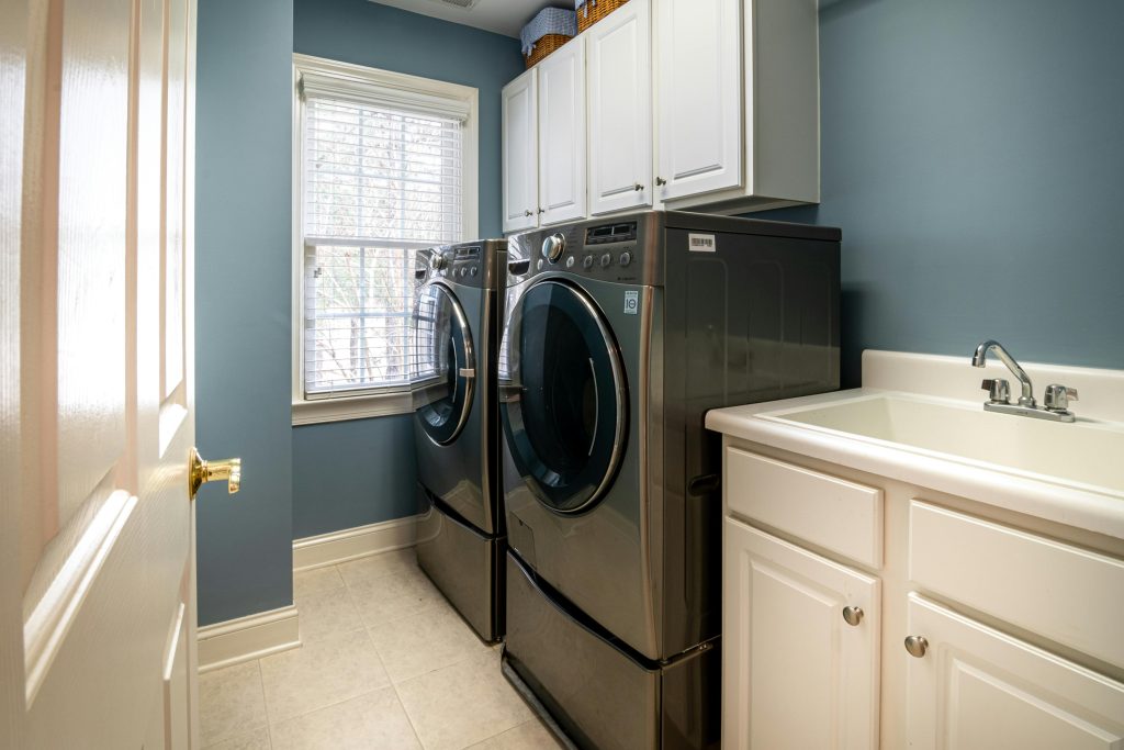 A clean, organized laundry room featuring modern appliances and ample storage.